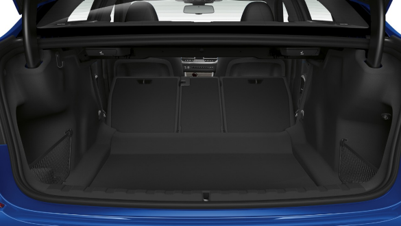 BMW 3 Series Sedan, trough-loading system. Close-up of the opened trunk with the rear backseats half folded down.