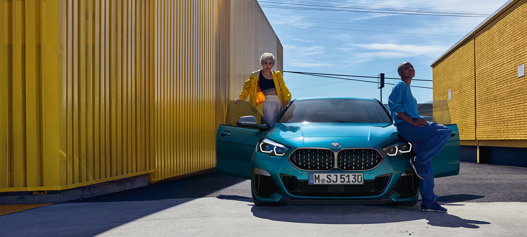 BMW 2 Series Gran Coupé F44, front view BMW 2 Series Gran Coupé F44 Snapper Rocks Blue, front view with open doors and two people at the vehicle