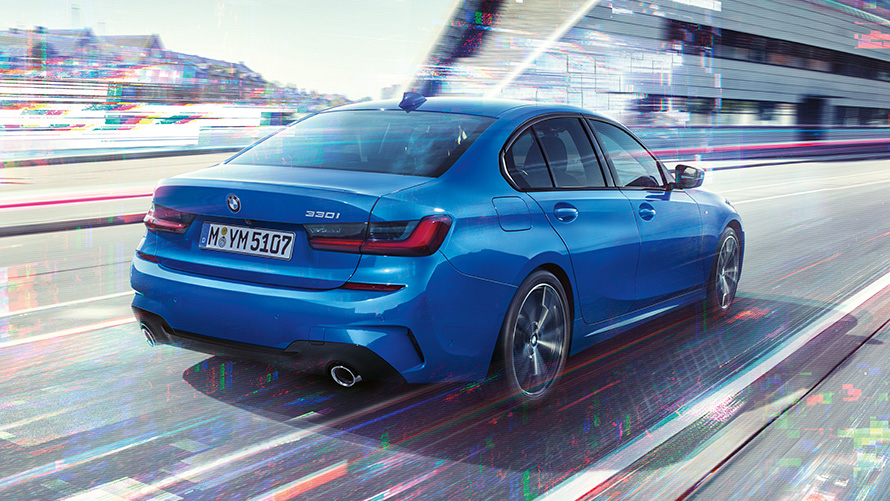 BMW 3 Series Sedan (G20), side rear shot. Three-quarter rear shot of the BMW 3 Series Sedan (G20) at day in front of an urban setting.
