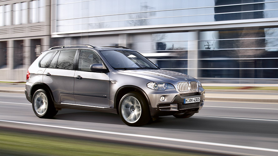 BMW X5 E70 second generation side view driving on the street BMW X Series BMW X5 E70 second generation side view driving on the street