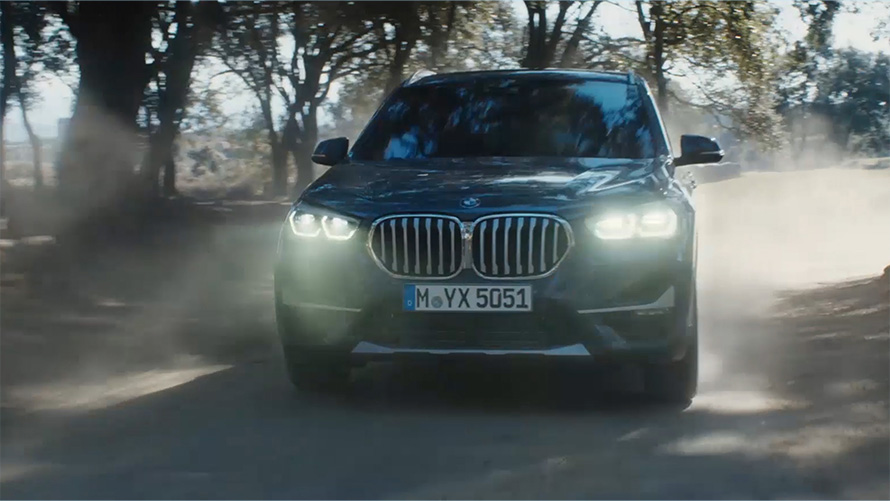 BMW X1 F48 LCI three-quarter front view BMW X1 F48 LCI three-quarter front view driving in front nature scenery