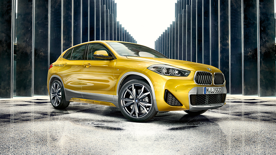 BMW X2 F39 Brooklyn Grey Three-quarter rear view with open door and two persons BMW X2 F39 Brooklyn Grey Three-quarter rear view with open door and two persons