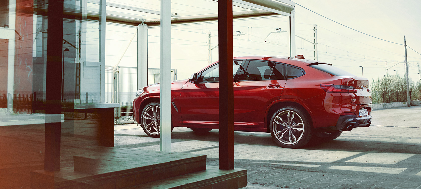 BMX X4 side view BMW X4 M40i G02 2018 Flamenco Red brilliant effect side view parking