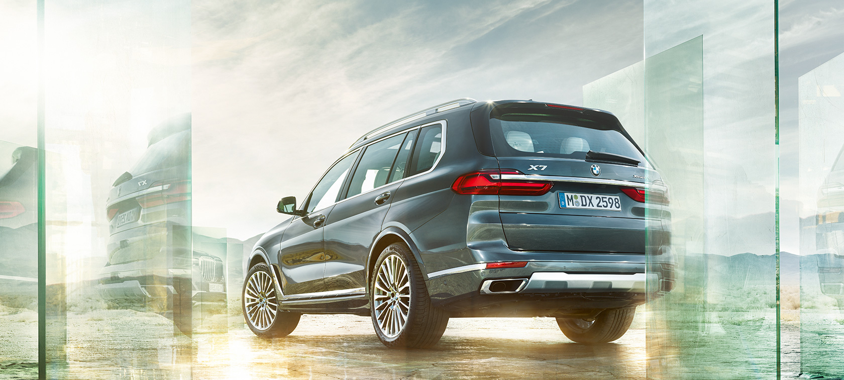BMW X7 G07 2019 Arctic Grey three-quarter rear view driving