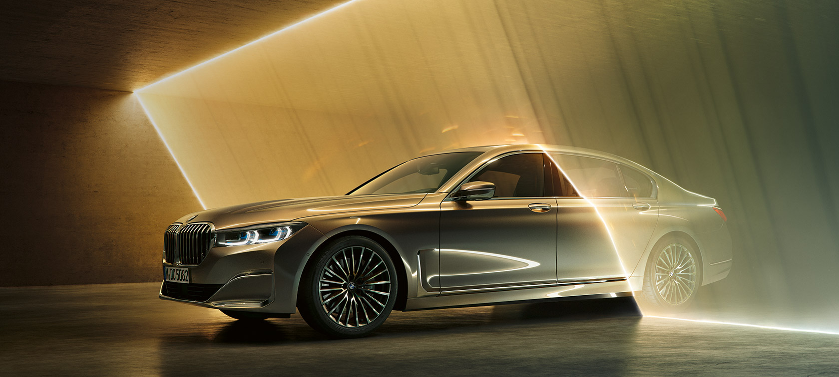 BMW 7 Series Sedan: grey BMW in three-quarter front view surrounded by beams of light