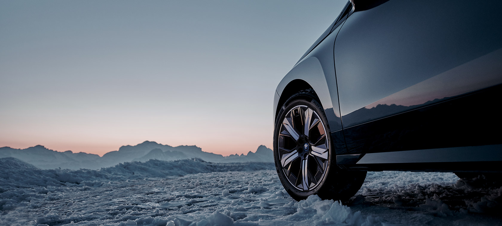 Original BMW Wheels on the BMW iX (I20) on snow in front of mountains Original BMW Wheels on the BMW iX (I20) on snow in front of mountains
