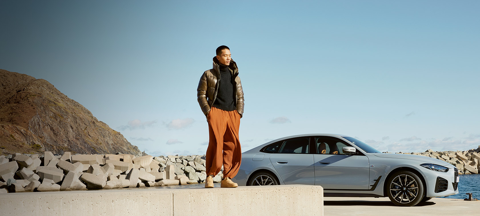 BMW Service Inclusive BMW Service Inclusive man in front of BMW i4 on the coast